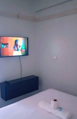 Double bed and wall-mounted TV inside the studio apartment in Kakamega town