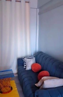 Lounge with blue sofa and cushions at The Praxing Nest studio apartment, Kakamega